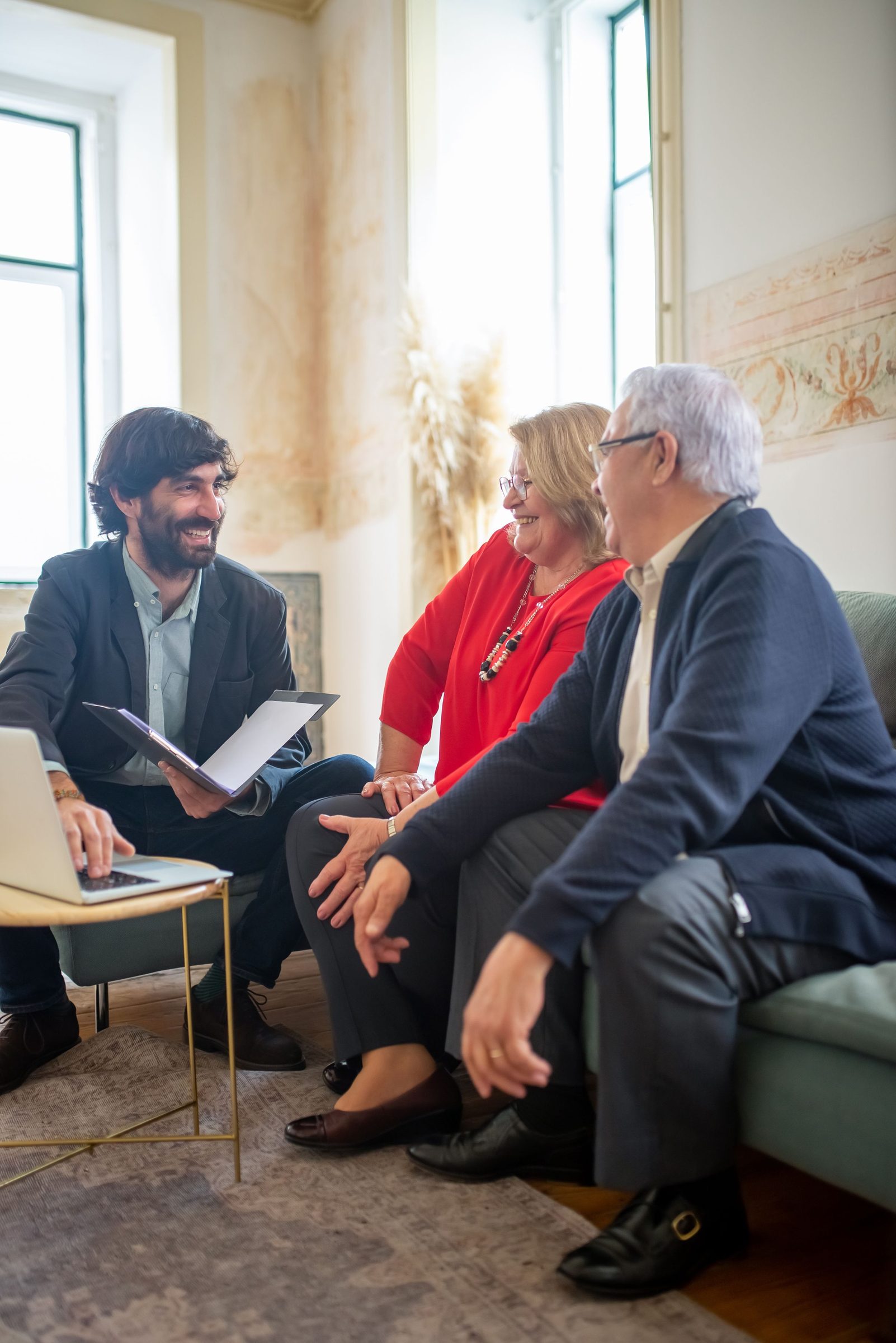 An adviser going through paperwork with an older couple at home