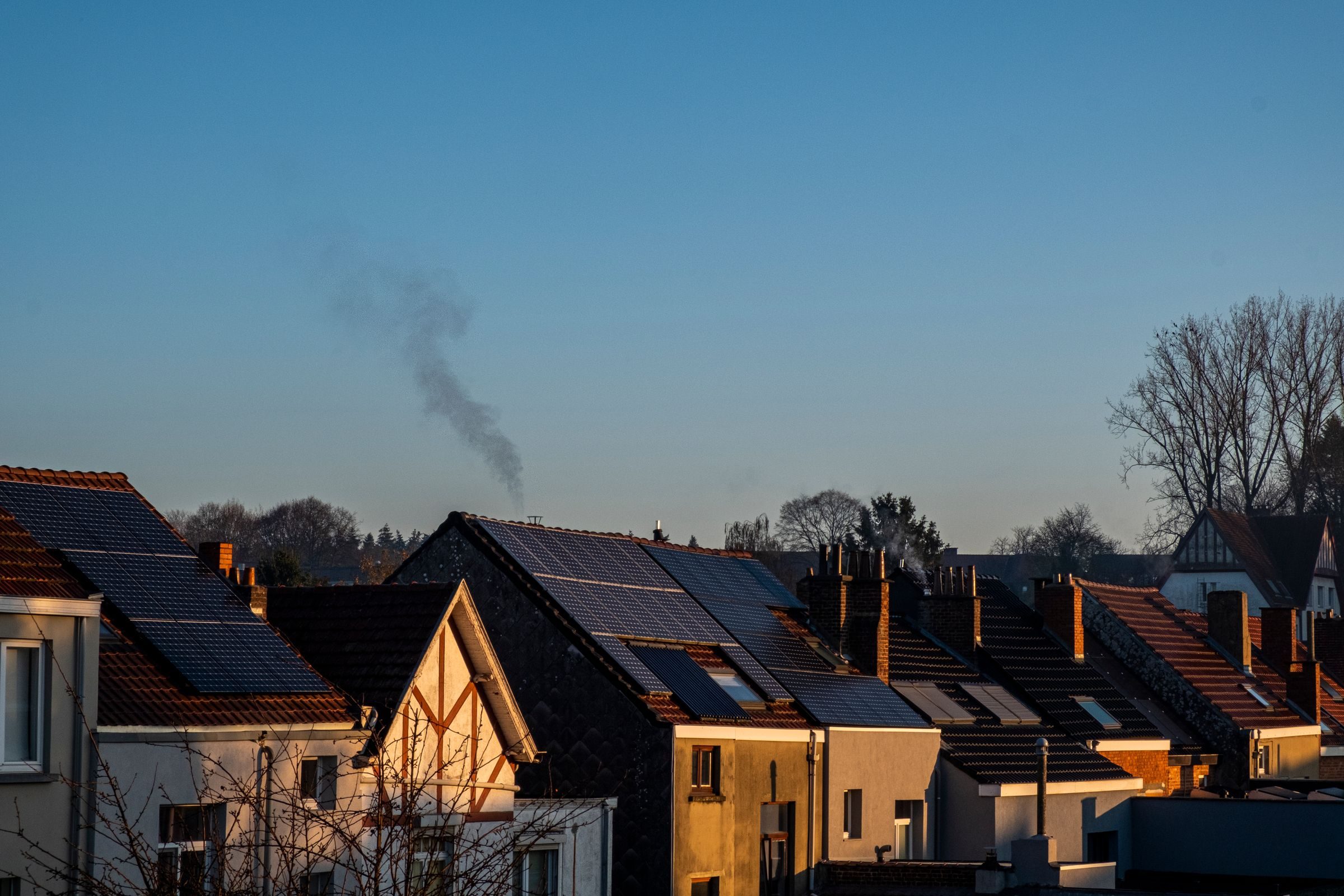 A row of houses with solar panels on their roofs at dusk