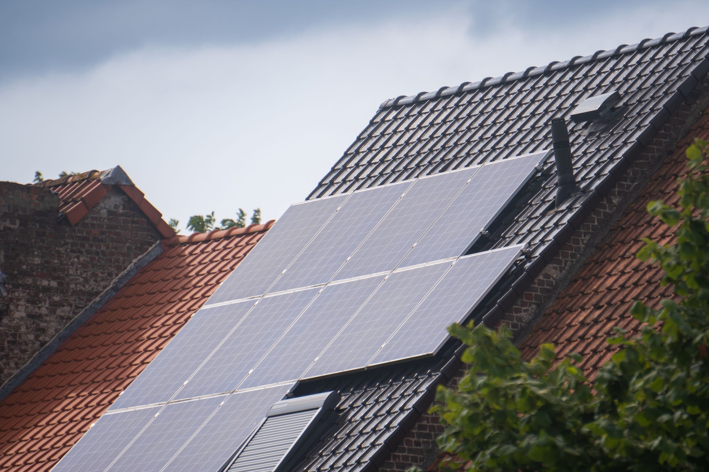A clean domestic solar array on a tiled roof under a grey sky