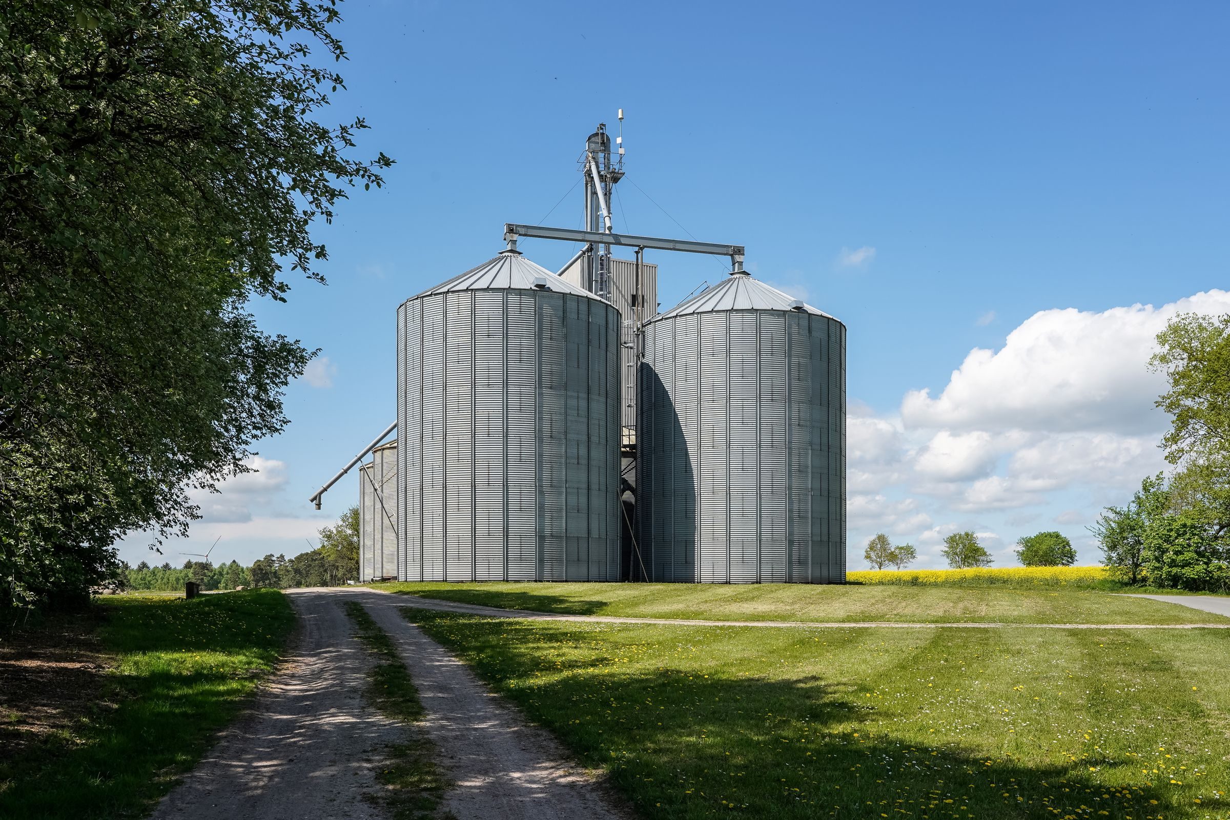 Grain silos and a dryer beside a farm track