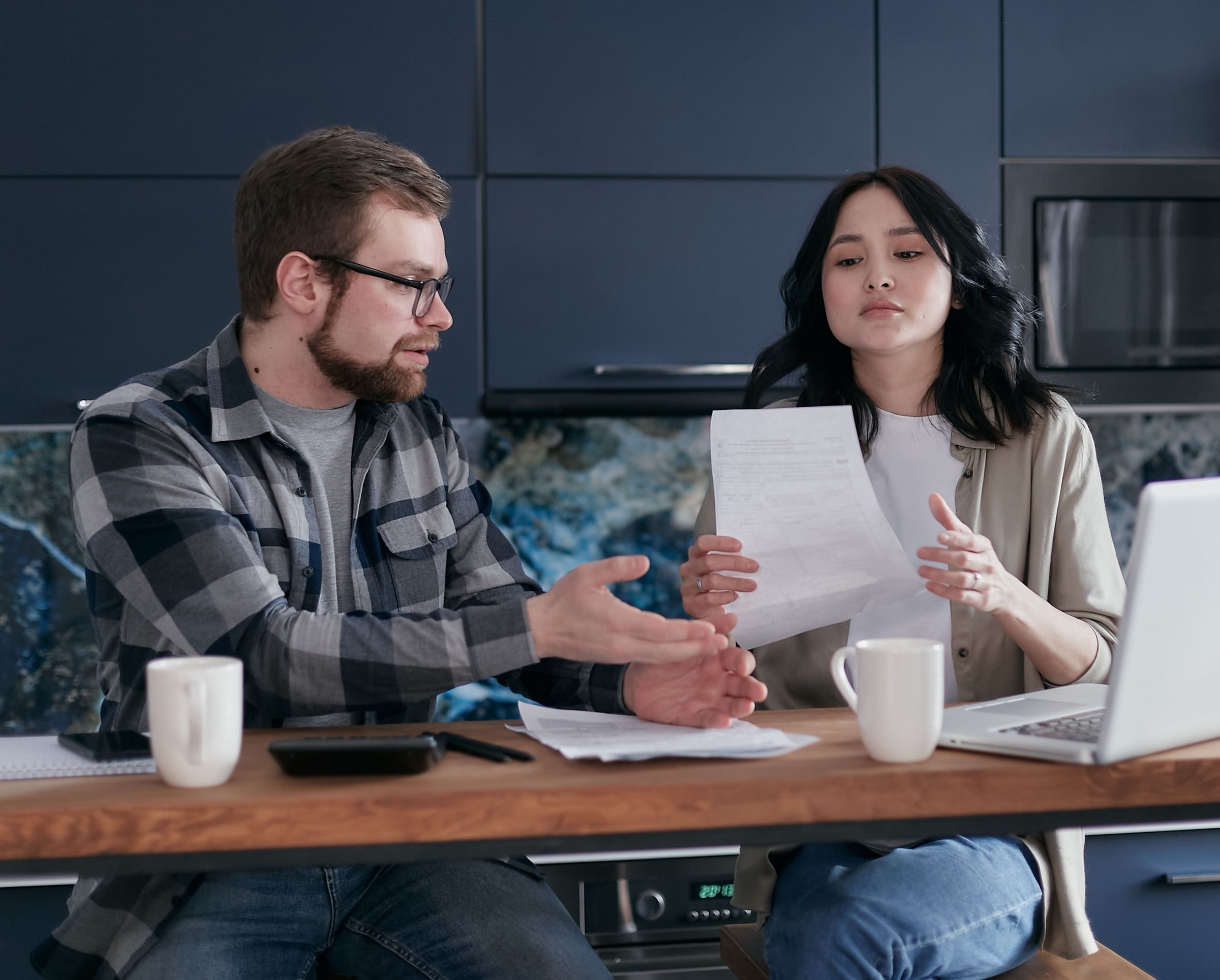 Two people going through paperwork at a kitchen table