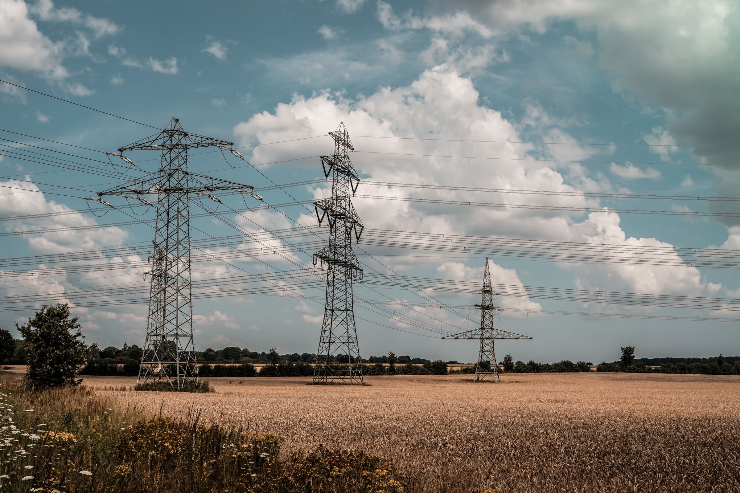 Pylons and overhead lines crossing open countryside