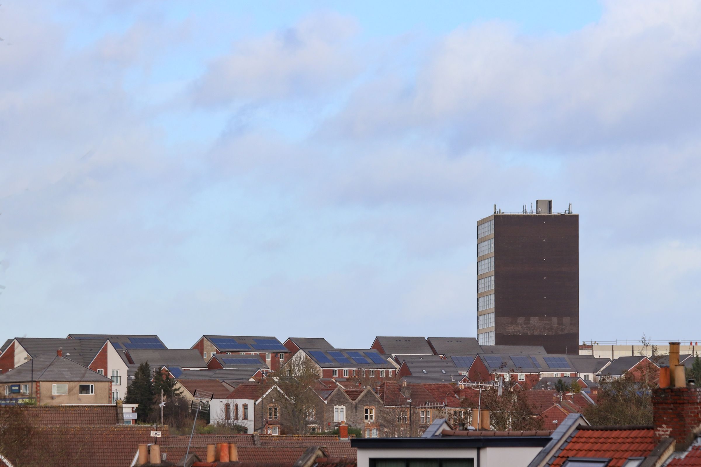 Rooftops of a northern English town, several with solar panels