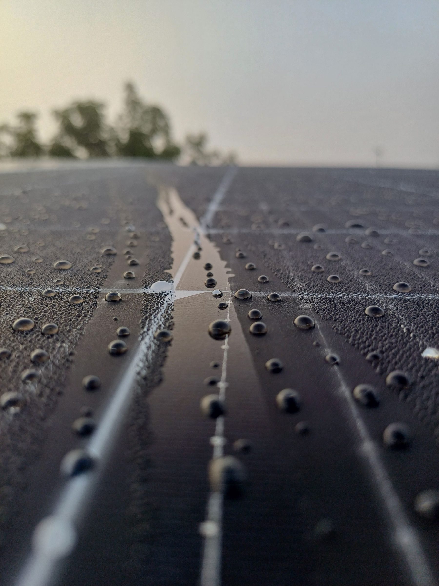 Rain water running down the glass of a solar panel
