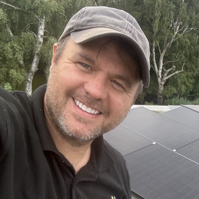 Tony Beckett, founder of DB Energy, on a roof with one of our arrays